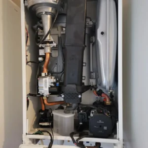 Interior view of a heating system showing various mechanical components and pipes.