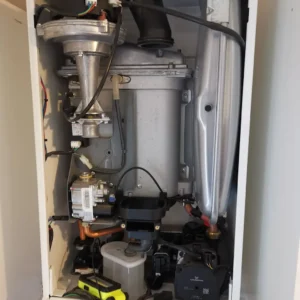 Interior view of a heating boiler showing various mechanical components and wiring.